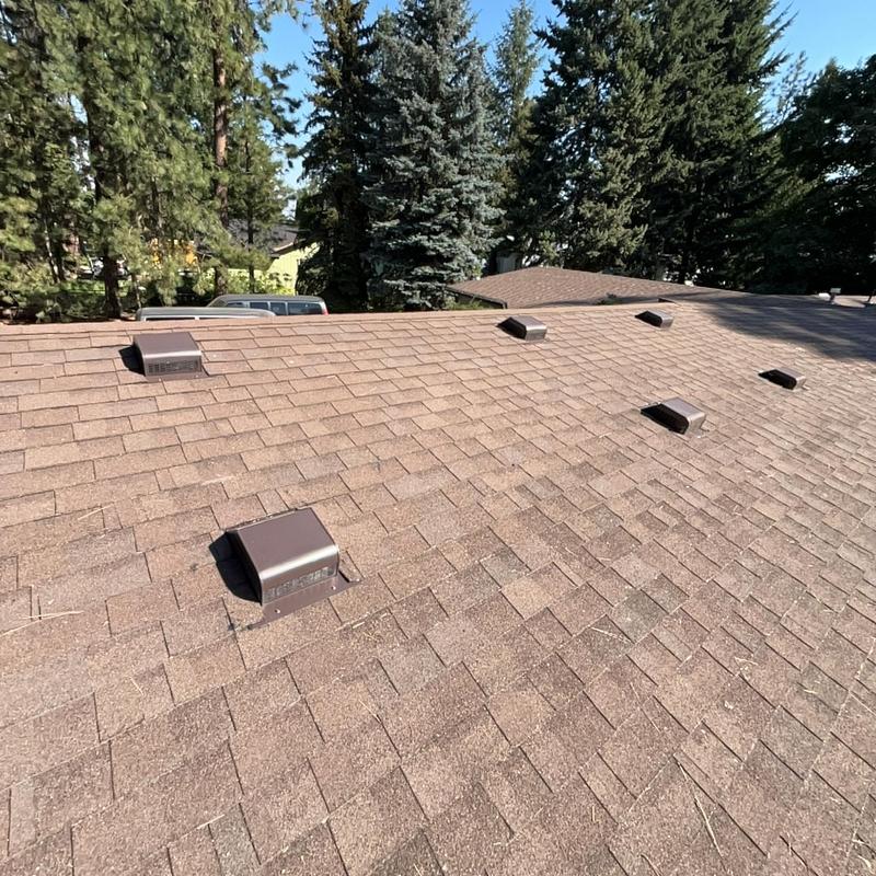 Asphalt shingle roof with multiple ventilation caps