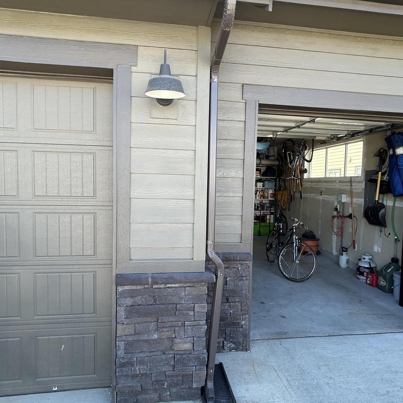 Downspout relocated to French drain beside garage door