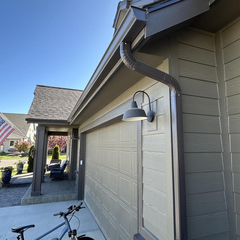 Gutter downspout extended to French drain on garage