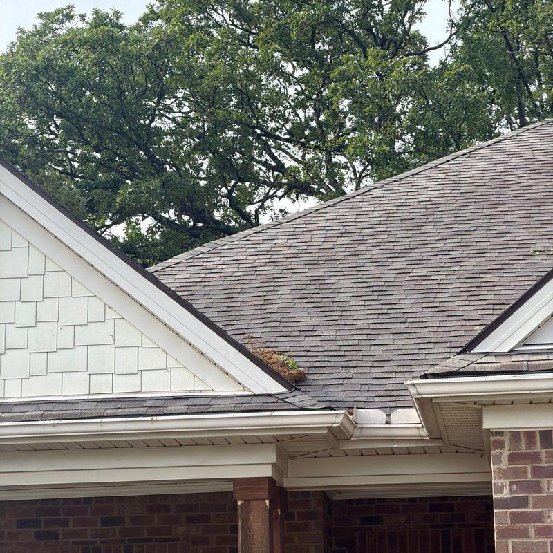 Asphalt shingle roof with debris in gutter area