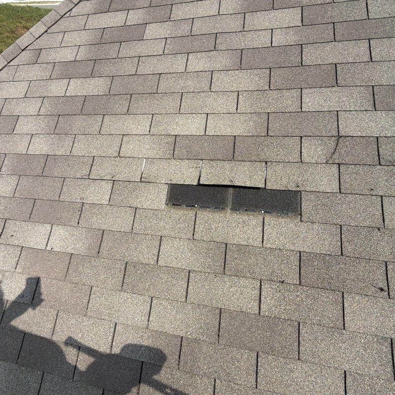 Roof shingles with storm damage and repairs needed