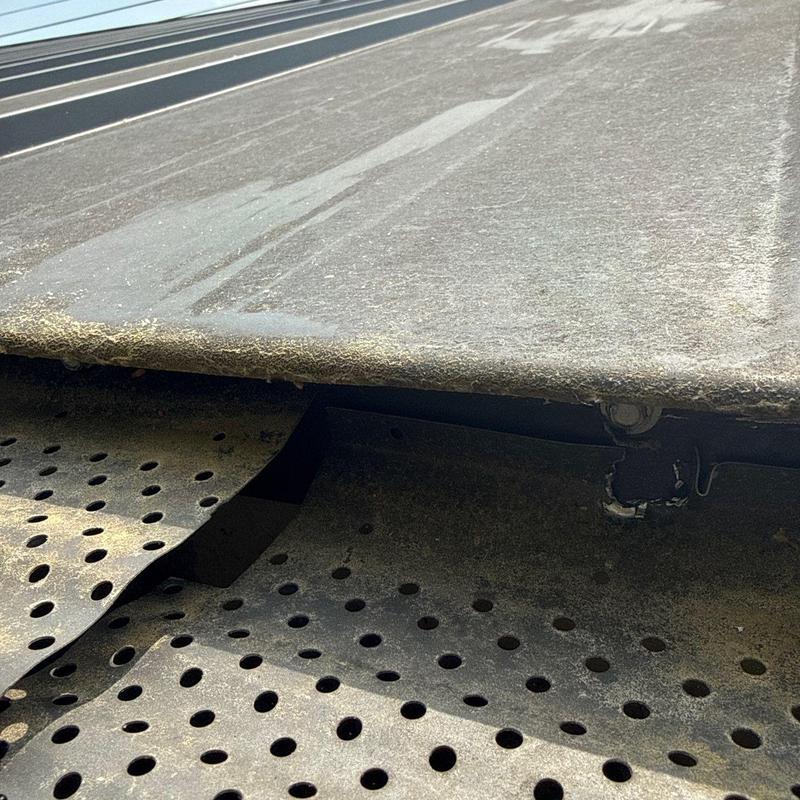 Commercial roof edge with damaged flashing and surface wear