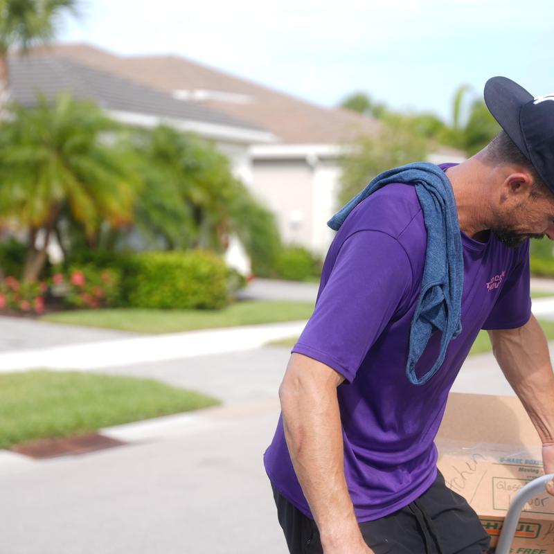 Moving boxes handled by worker in residential neighborhood