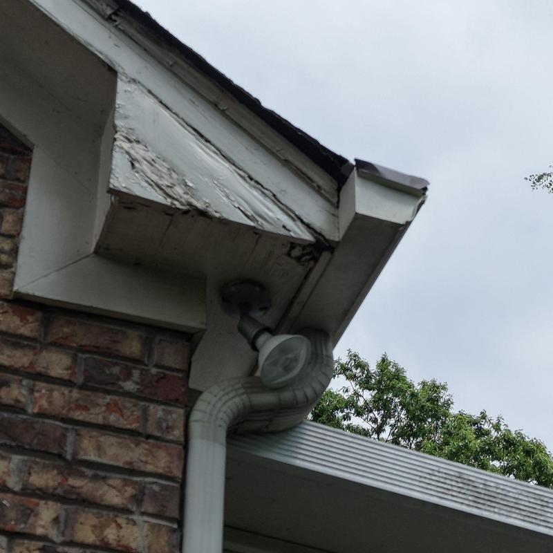 Wood fascia board with peeling paint and trim damage