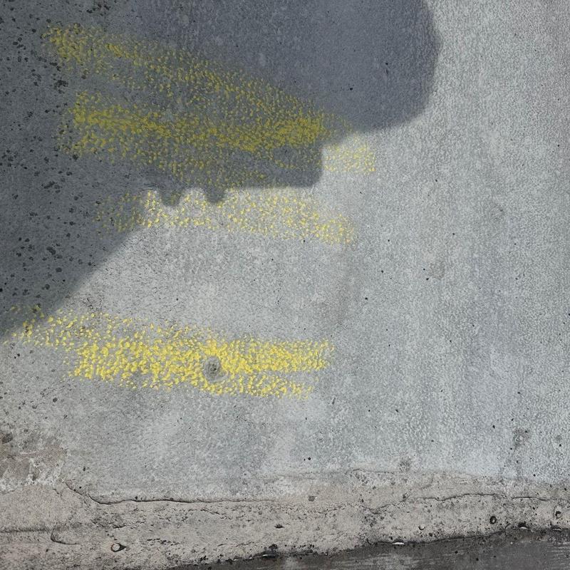 Concrete floor surface with faded yellow markings
