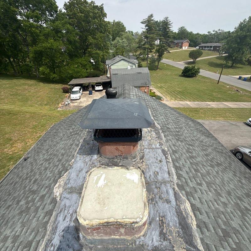 Chimney flashing and roof shingles with weather damage