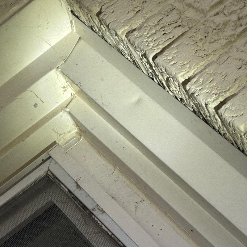 Window frame close-up showing paint cracks and wear