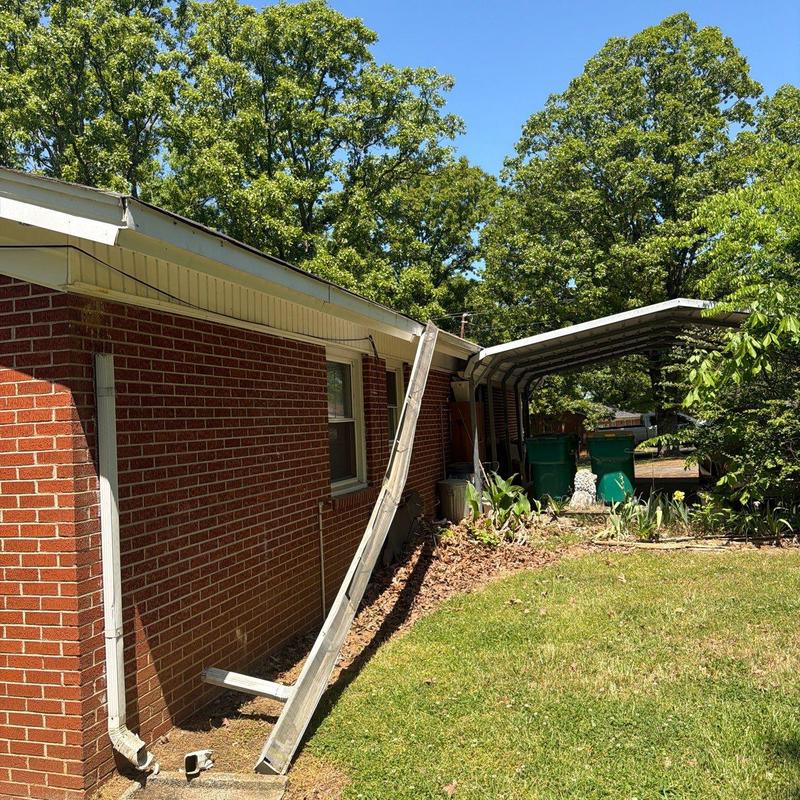 Gutter system leaning against brick house wall