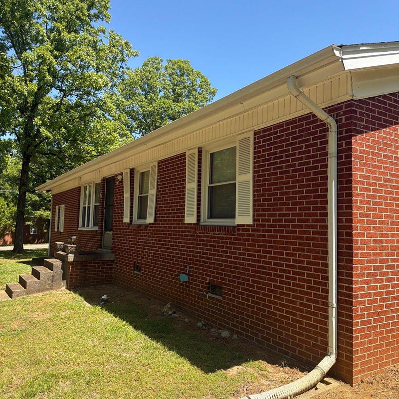 Gutter downspout and brick exterior of house