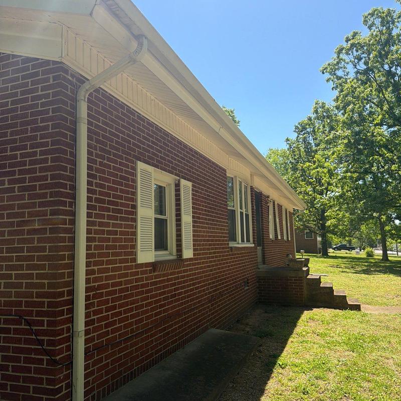 Roof shingles and gutters inspection on brick house