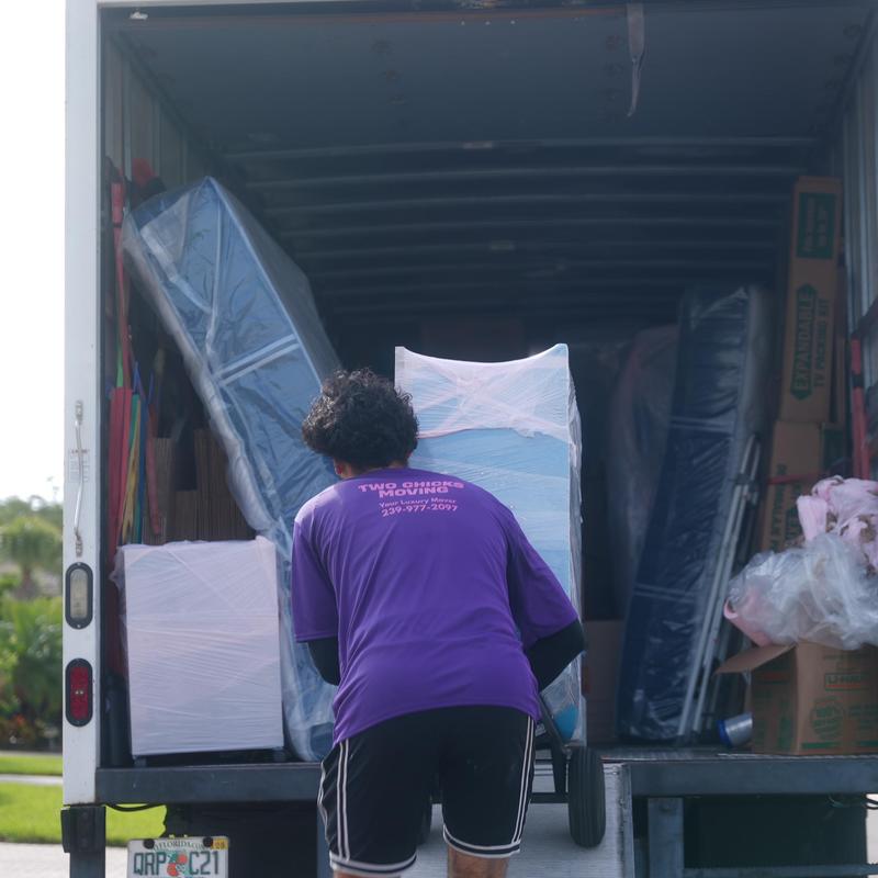 Wrapped furniture being loaded into moving truck