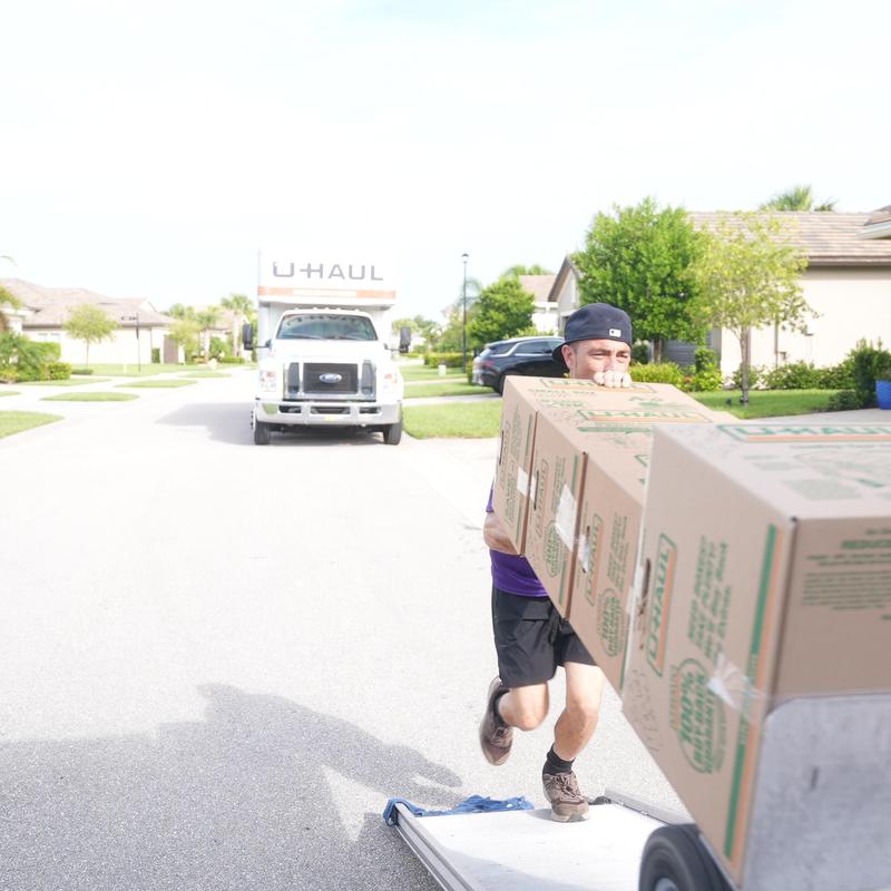 Moving boxes carrying onto dolly near U-Haul truck