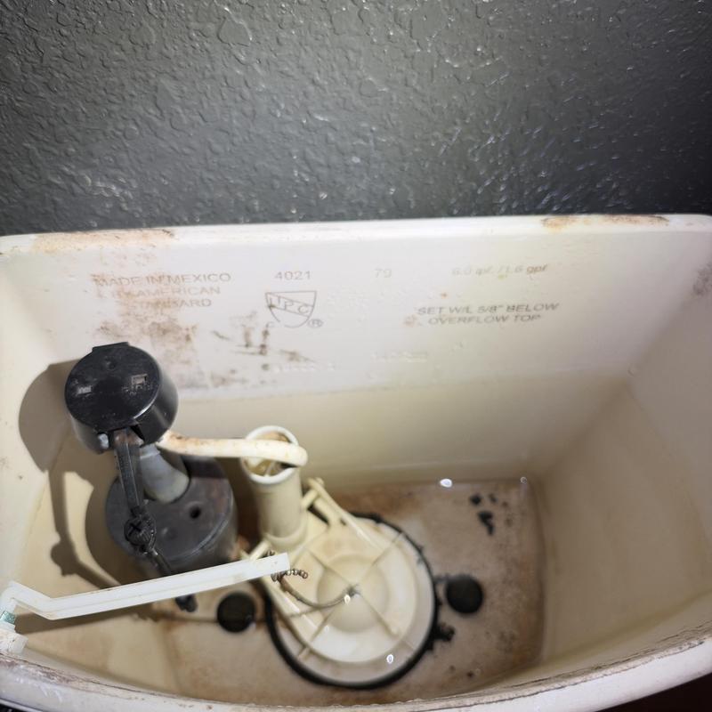 Toilet tank refill valve and flapper assembly inside tank