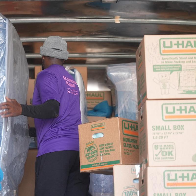 Moving boxes and mattress inside truck during loading