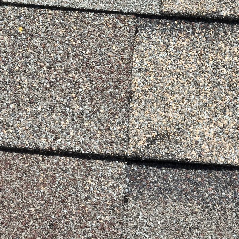 Asphalt shingles with hail damage repair close-up Asphalt shingles with hail damage repair close-up