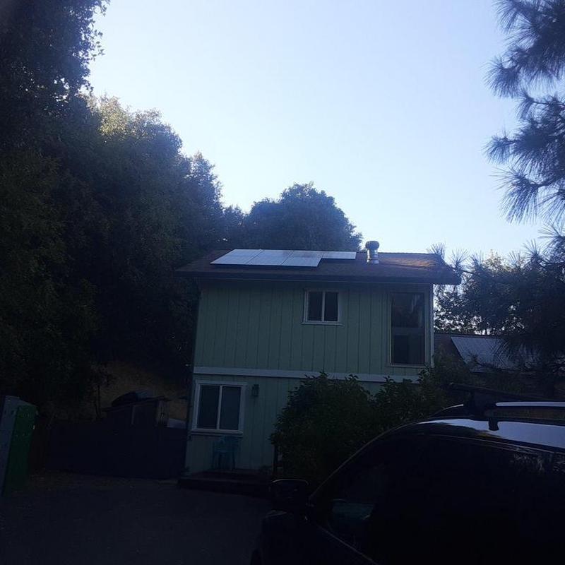Solar panels installation on green two-story house roof Solar panels installation on green two-story house roof