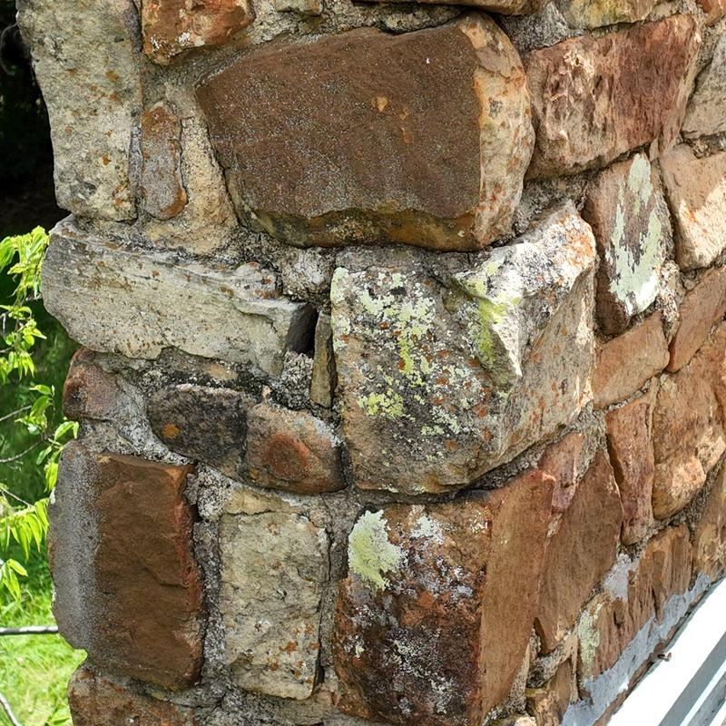 Stone masonry corner with weathered and lichen-covered blocks Stone masonry corner with weathered and lichen-covered blocks