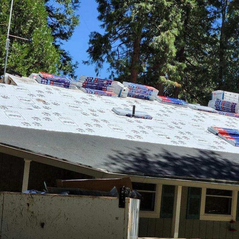 GAF asphalt shingles stacked on roof underlayment