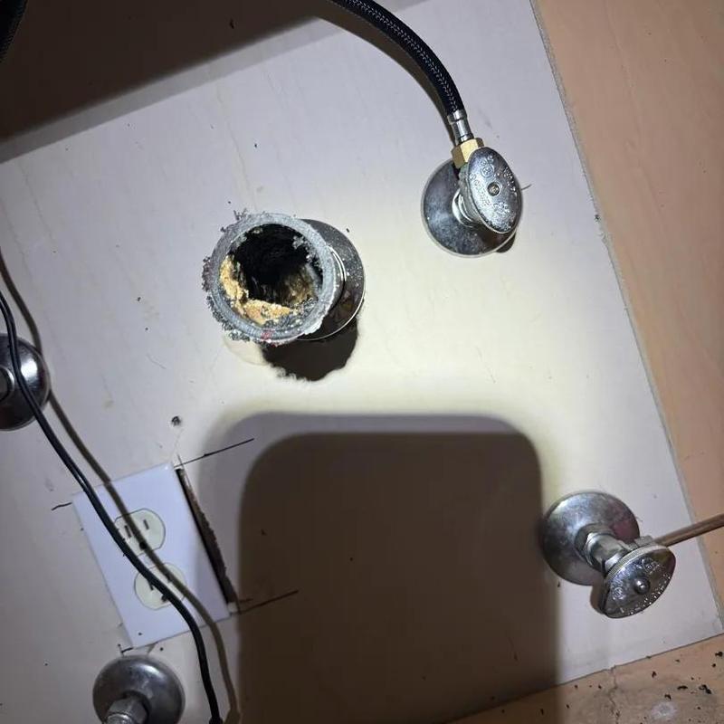 Drain pipe with buildup and water valves under sink Drain pipe with buildup and water valves under sink