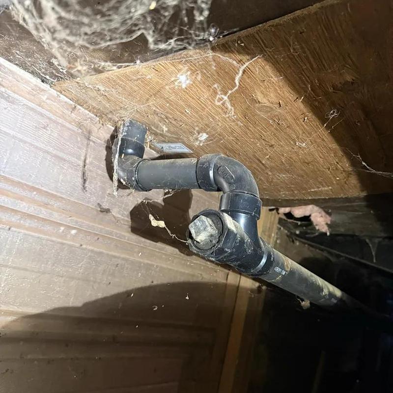 Plastic drain line with elbow joint in crawl space Plastic drain line with elbow joint in crawl space