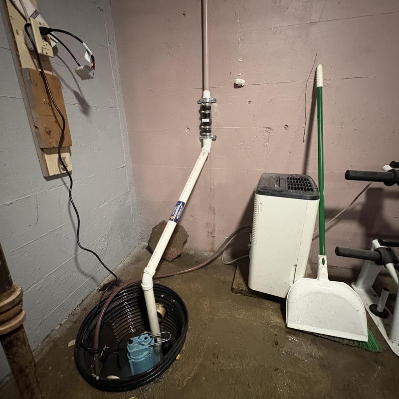 Sump pump basin with new check valve and piping secured Sump pump basin with new check valve and piping secured