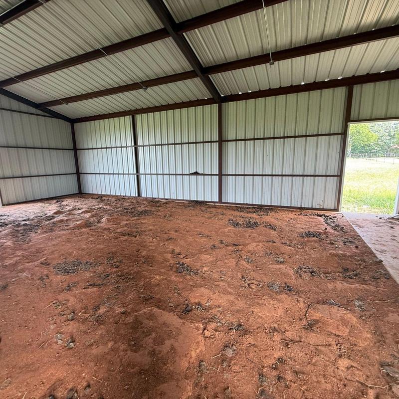 Metal building interior with dirt floor and open door Metal building interior with dirt floor and open door