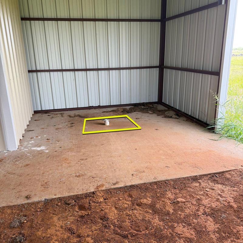Concrete slab with plumbing pipe in metal shed Concrete slab with plumbing pipe in metal shed