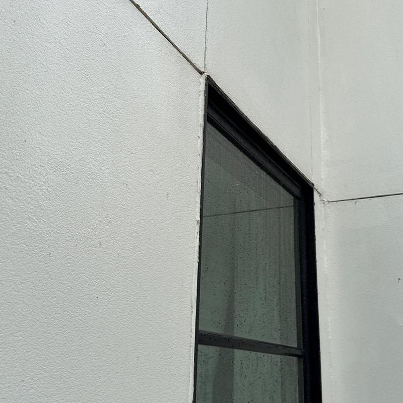 Stucco exterior wall with sealed window frame Stucco exterior wall with sealed window frame