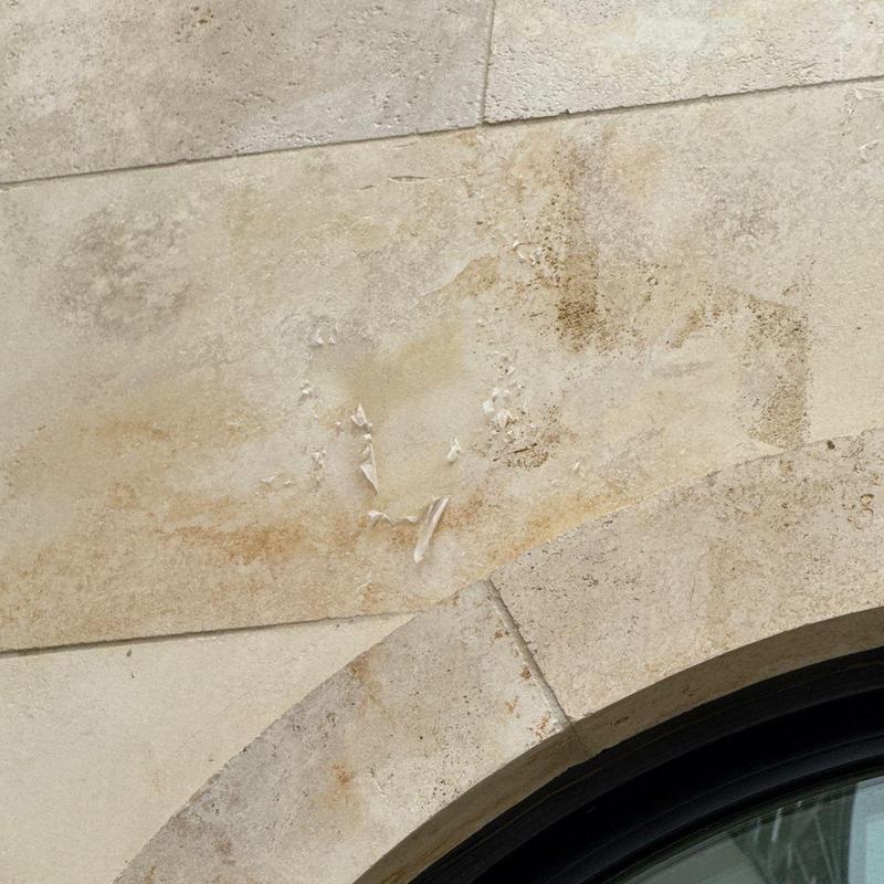 Stucco wall with peeling and water damage near arch window Stucco wall with peeling and water damage near arch window