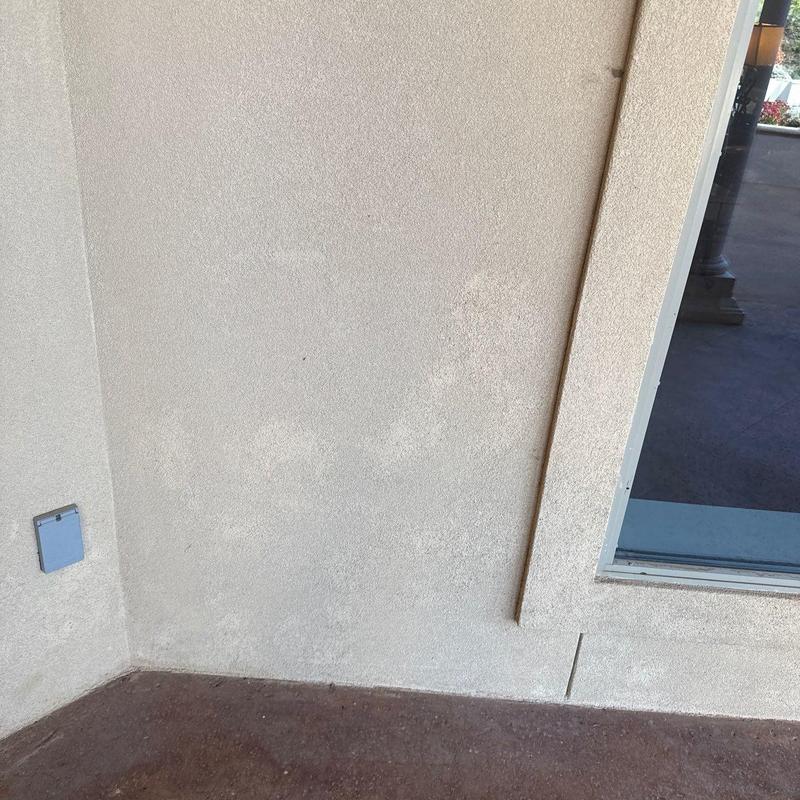 Stucco wall corner with crack repair near window Stucco wall corner with crack repair near window