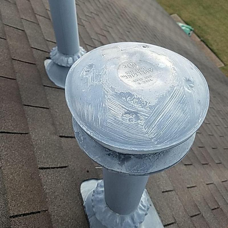 Roof vent pipe with metal cap on shingle roof
