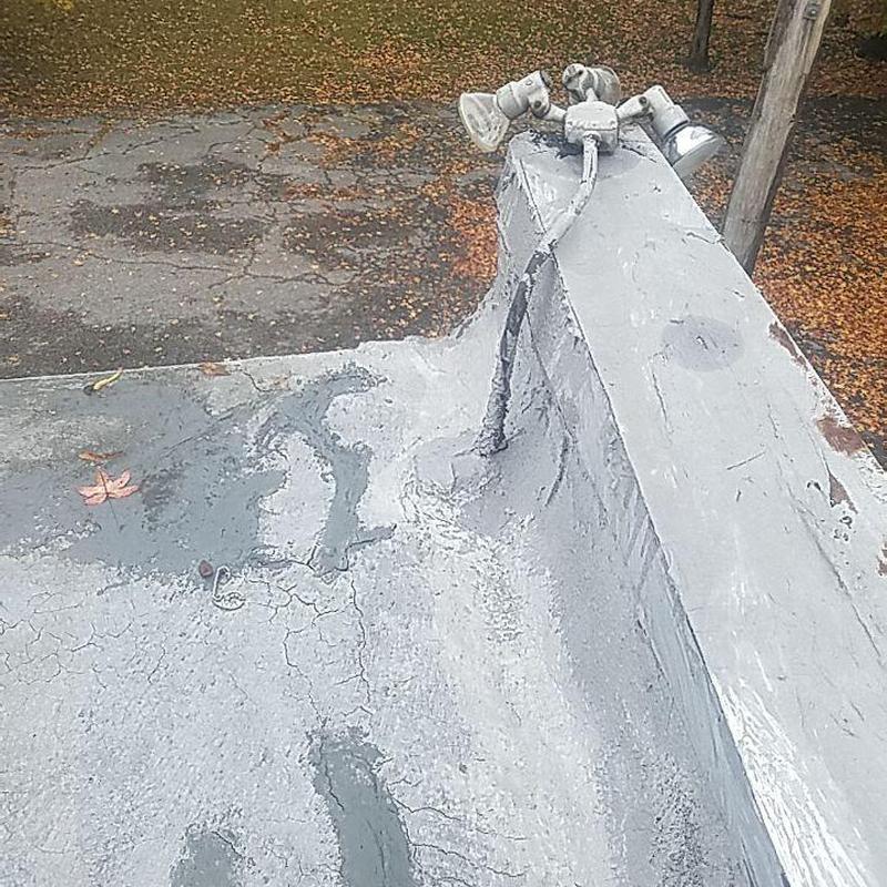 Concrete commercial roof with floodlights on parapet wall