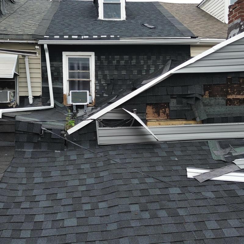 Asphalt shingle roof with severe damage and missing sections Asphalt shingle roof with severe damage and missing sections