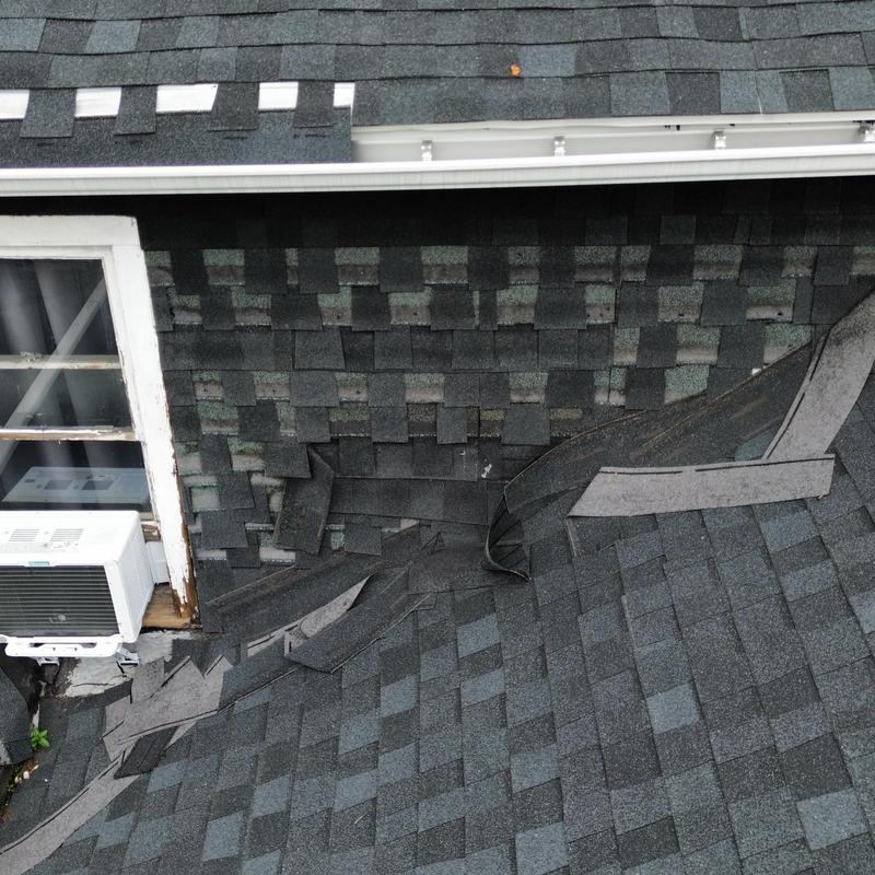 Asphalt shingle roof damage with peeling and missing shingles Asphalt shingle roof damage with peeling and missing shingles