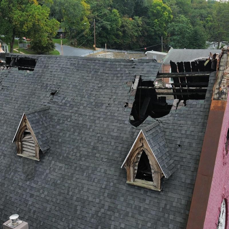 Roof shingles with large fire damage hole Roof shingles with large fire damage hole