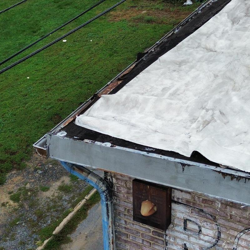 EPDM commercial roof edge pulling back with wind damage EPDM commercial roof edge pulling back with wind damage