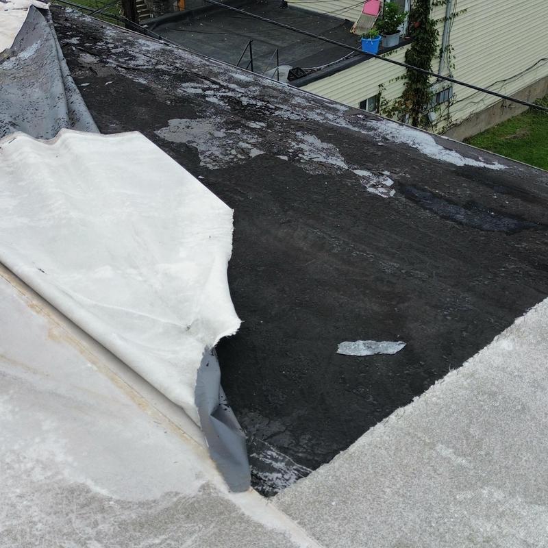EPDM commercial roof with wind damage and peeling edge EPDM commercial roof with wind damage and peeling edge