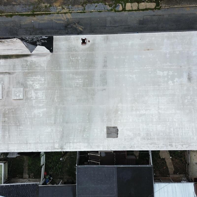EPDM commercial roof with wind damage and peeling edge EPDM commercial roof with wind damage and peeling edge