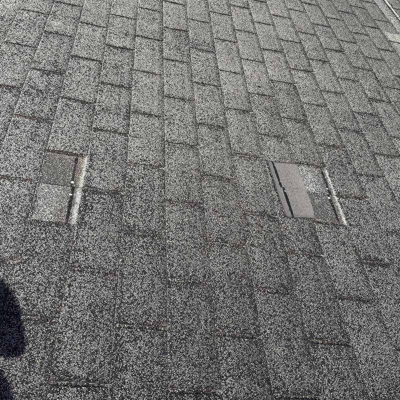 Asphalt roof shingles with heavy granule loss and damage Asphalt roof shingles with heavy granule loss and damage