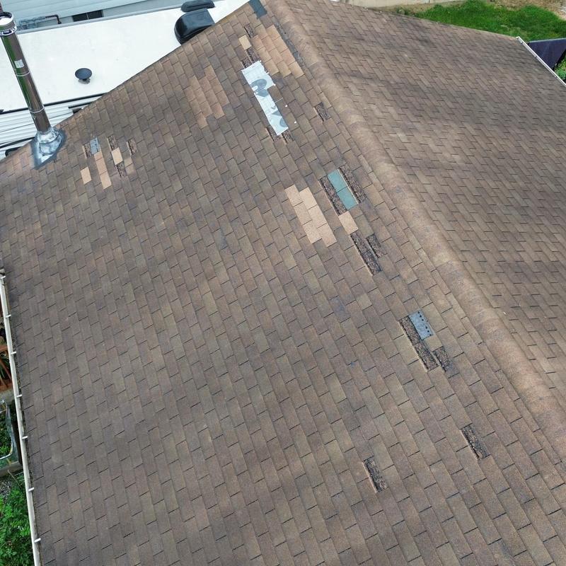 Asphalt shingle roof with wind damage and patch repairs Asphalt shingle roof with wind damage and patch repairs