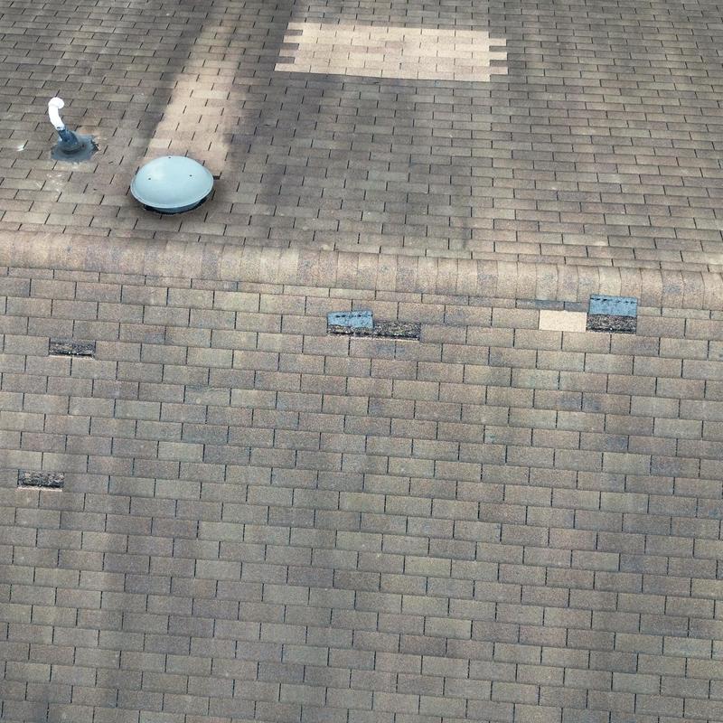 Asphalt shingle roof with wind damage and patch repairs Asphalt shingle roof with wind damage and patch repairs