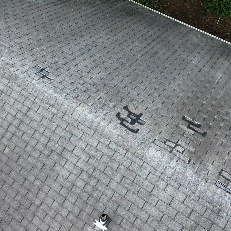 Residential asphalt shingle roof with marked wind damage Residential asphalt shingle roof with marked wind damage