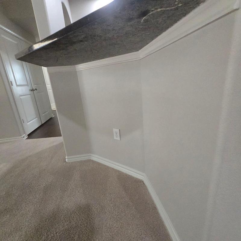 Electrical outlet on carpeted wall corner beneath counter Electrical outlet on carpeted wall corner beneath counter