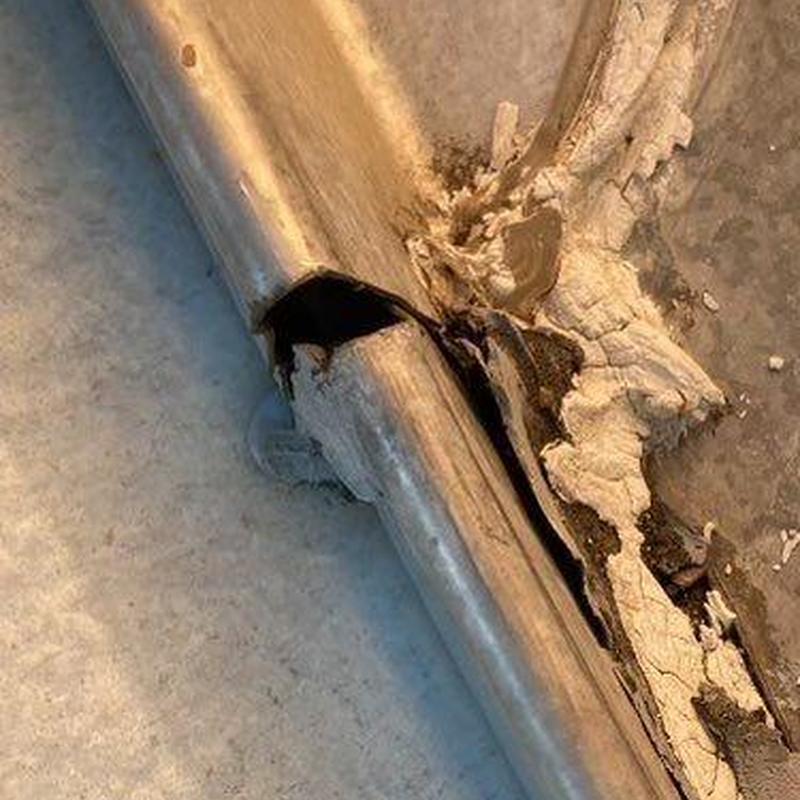 Damaged metal pipe with torn surrounding material Damaged metal pipe with torn surrounding material
