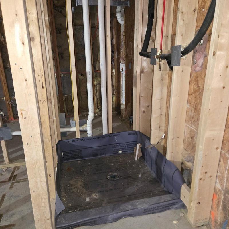 Shower pan installation with plumbing and framing in progress Shower pan installation with plumbing and framing in progress