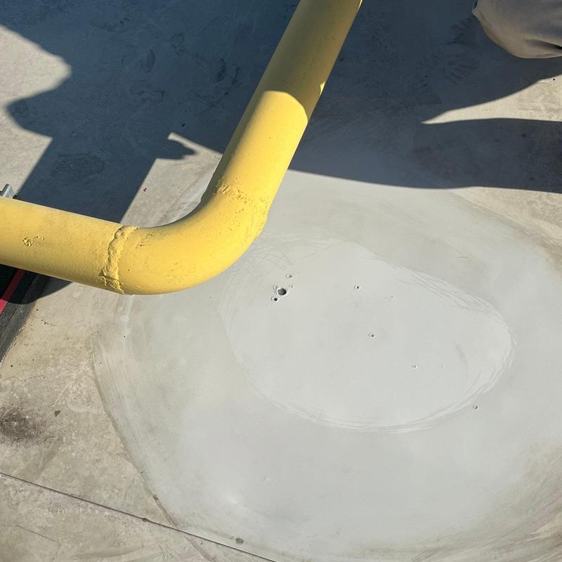 Concrete commercial roof patch near yellow pipe on rooftop Concrete commercial roof patch near yellow pipe on rooftop