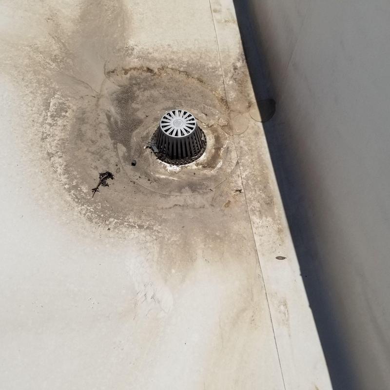 Roof drain on flat roofing with surrounding discoloration Roof drain on flat roofing with surrounding discoloration