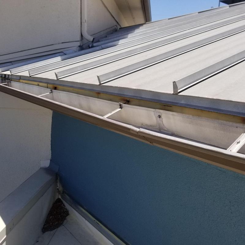 Metal roof panels and gutter installation on residential building Metal roof panels and gutter installation on residential building