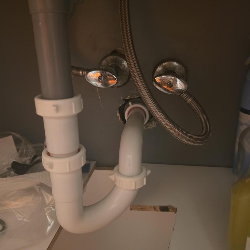 Plastic drain pipe with tubular fitting under sink