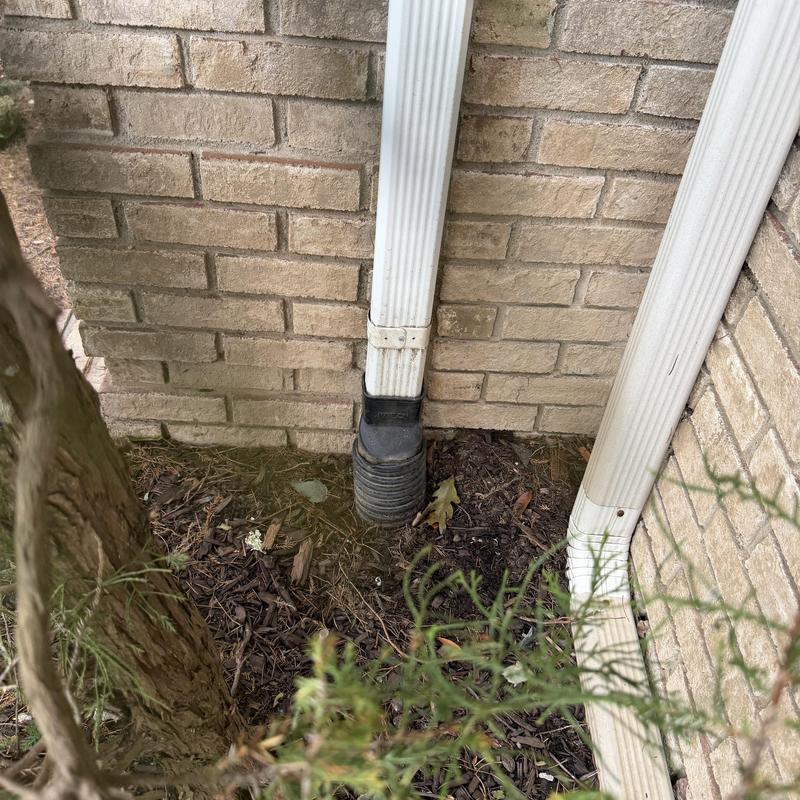 Downspout drainage lines at brick house corner outdoors Downspout drainage lines at brick house corner outdoors